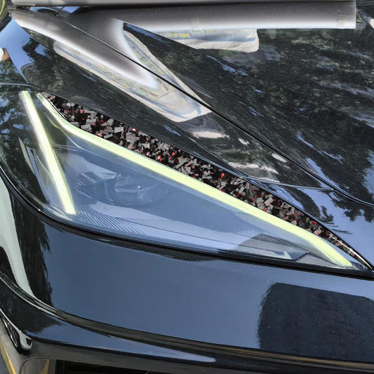 Car light eyebrow decal installed on headlight, carbon-fiber look with red foil speckles