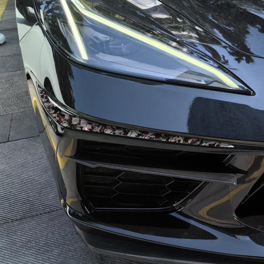 Bumper corner sticker on car, carbon-fiber pattern with red accents along front bumper edge
