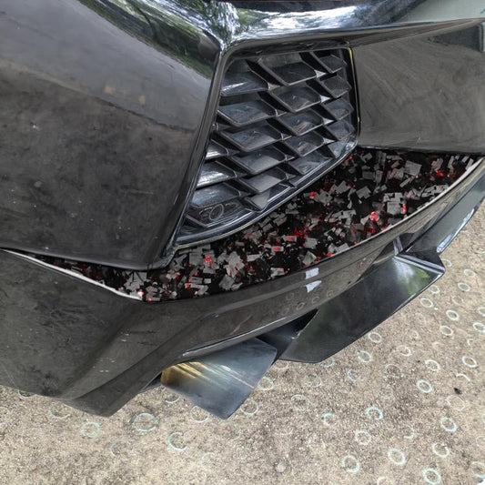 Rear air vent decorative sticker close-up, black carbon fiber with red foil flecks
