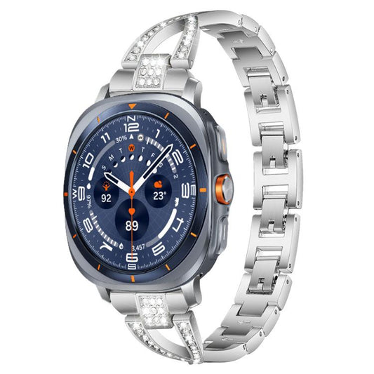 Silver X-shaped metal watch band with crystal accents, shown on a smartwatch.