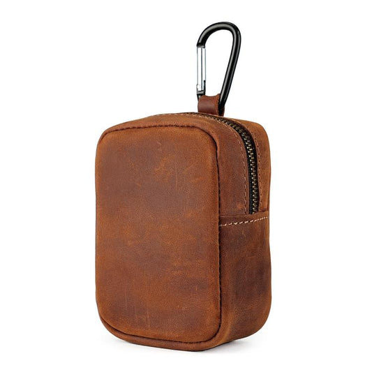 Tan leather coin pouch with front zipper and metal carabiner clip.