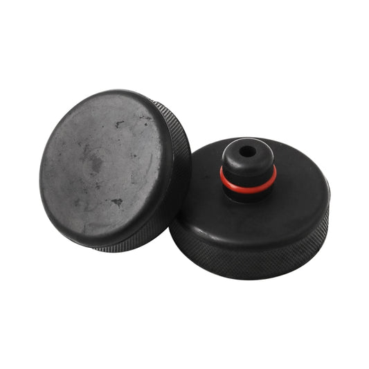 Two black rubber lift pads with red-ring center stud, with top cap