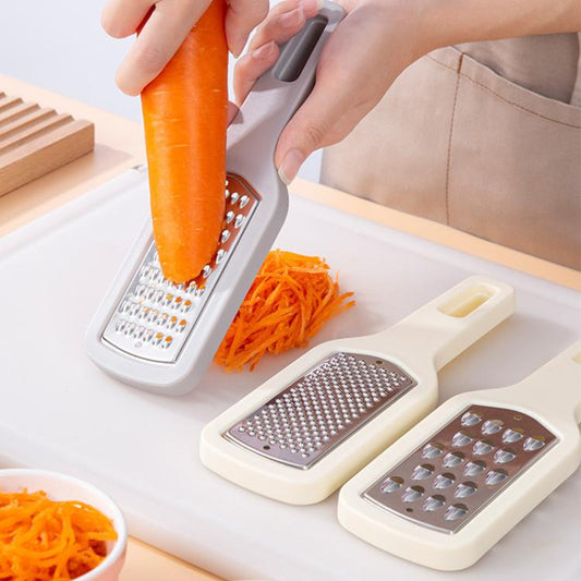 Stainless steel vegetable grater with fine shred plate, grating an orange carrot