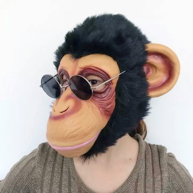Gorilla face mask worn with round sunglasses and black plush fur hood