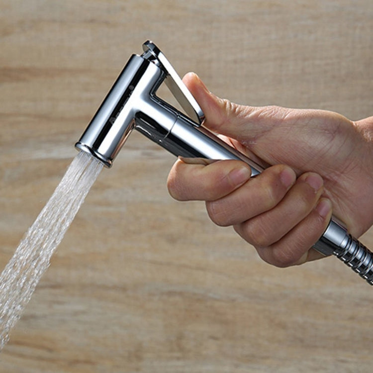 Handheld chrome bidet sprayer spraying water with ergonomic grip