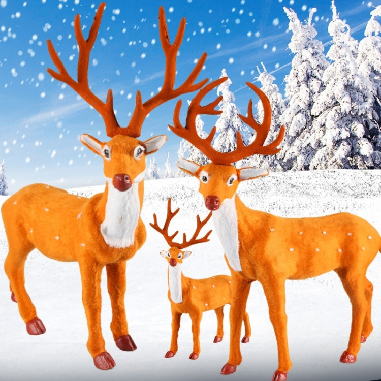 Group of simulated deer figurines with orange coats, white muzzles, and branched antlers.