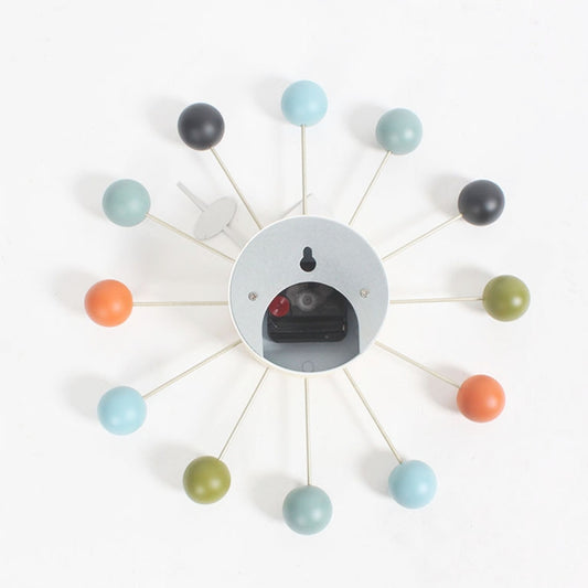 Wall clock with light blue and orange ball arms, round gray face with display window