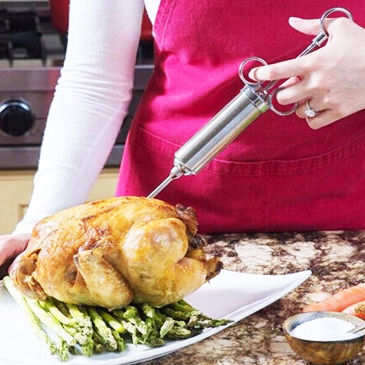 Cook using stainless steel injector on a roasted chicken breast during seasoning