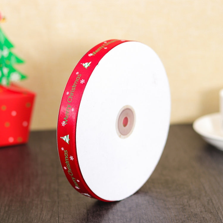 Red 'Merry Christmas' ribbon roll on white spool, angled close-up