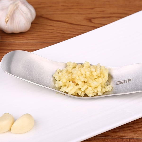 SSGP stainless steel garlic presser with chopped garlic on perforated plate, side angle