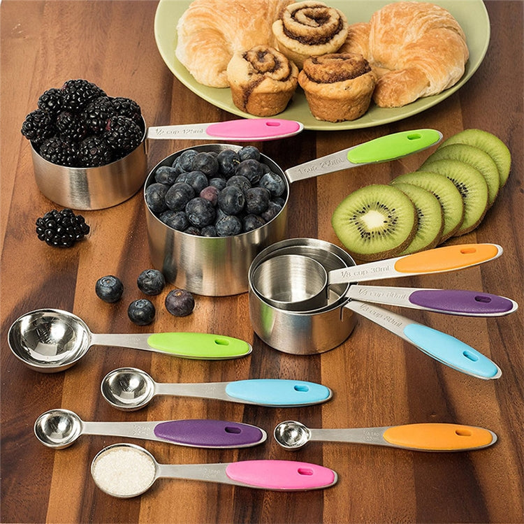 Measuring spoon set with stainless steel cups and colorful handles on a kitchen tray