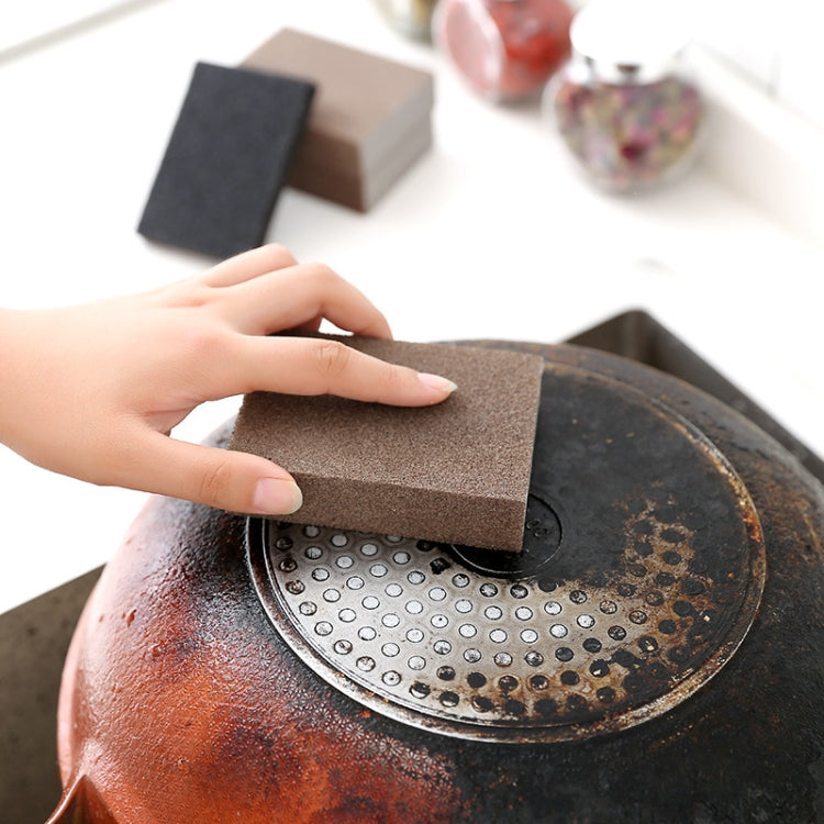 Emery rust-cleaning sponge pressed on perforated metal pot base with rust spots.