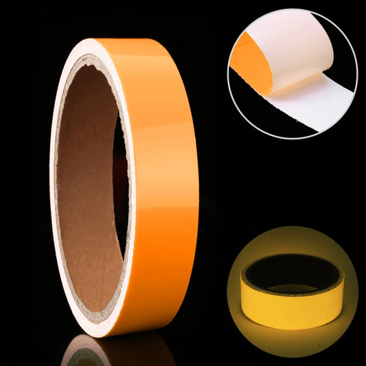 Glow-in-the-dark luminous tape roll with orange outer layer and tan adhesive backing