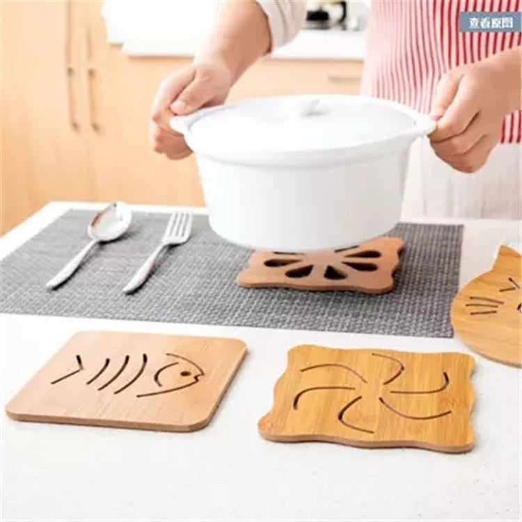 Wooden cartoon coaster mats under a serving pot, with several face designs