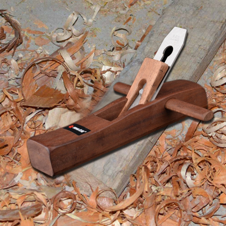 Wood planer lying on wood shavings, wooden body with steel cutter blade