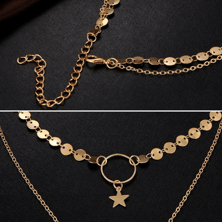Gold layered chain necklace detail with star pendant, oval links, and ring clasp