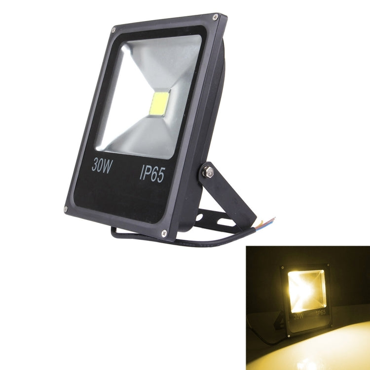 Black 30W LED floodlight casting warm yellow light, IP65 housing