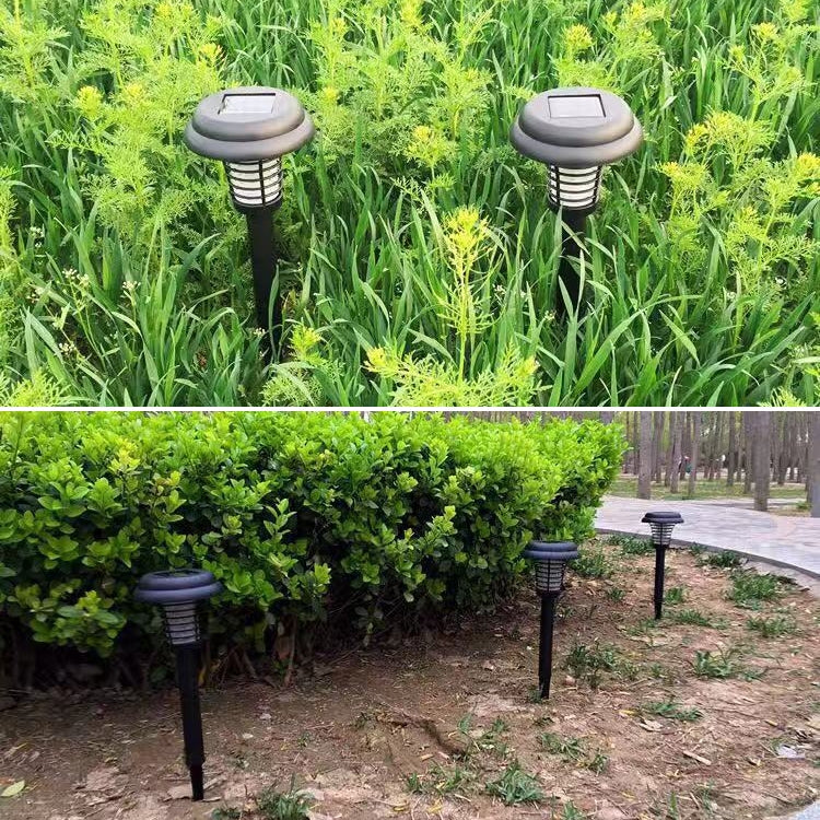 Two black solar mosquito pest lights standing in garden shrubs and a walkway