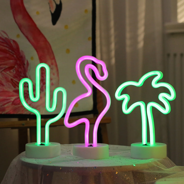 Flamingo decorative LED night light with pink neon outline on a white round base, among cactus lights.