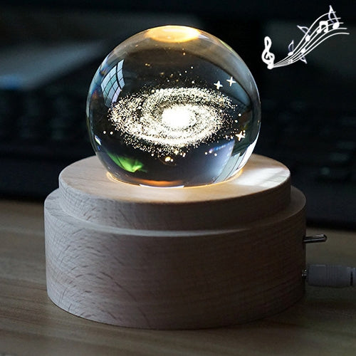 Glowing crystal ball music box night light with starry swirl projection on round wooden base.
