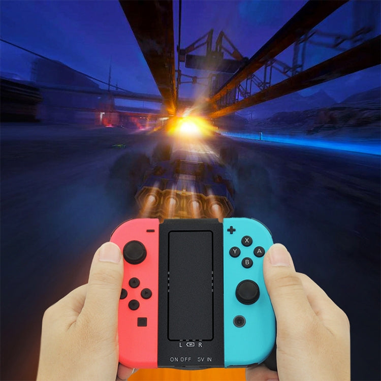 Hands holding coral and light blue Joy-Con grip charger with built-in center display