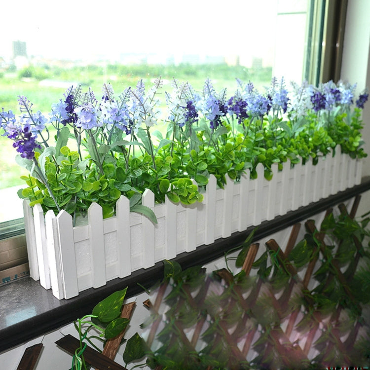 White picket-fence planter with purple blossoms and green foliage along the rail