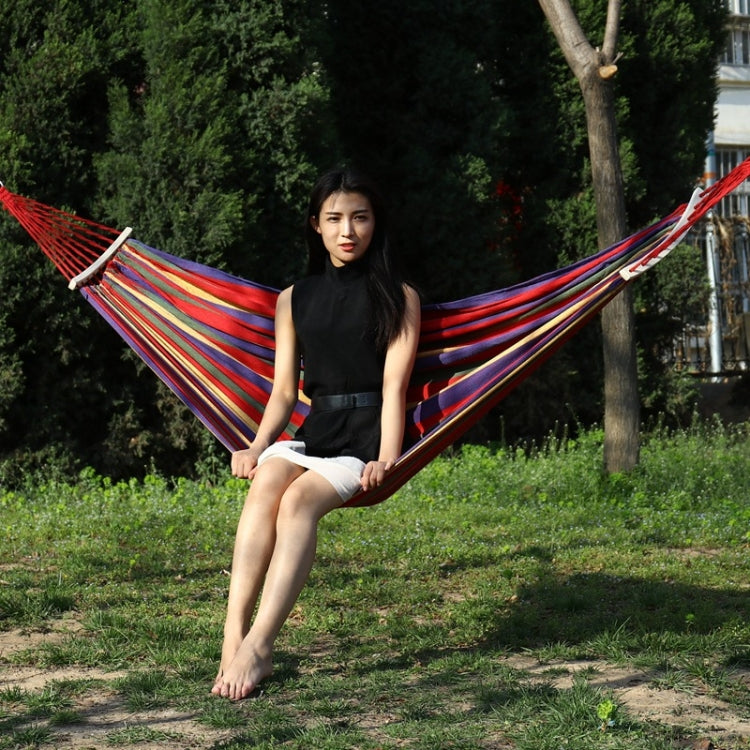 Red striped double hammock swing with wooden spreader and hanging ropes
