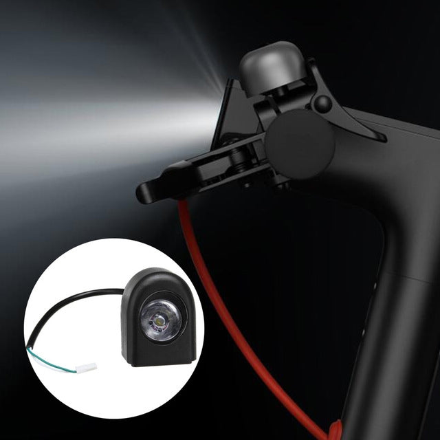 Black LED headlight and cable near scooter front cover, clear lens visible