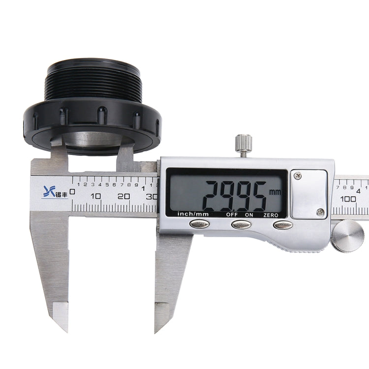 Black press-fit bottom bracket cup shown with calipers measuring the threaded side