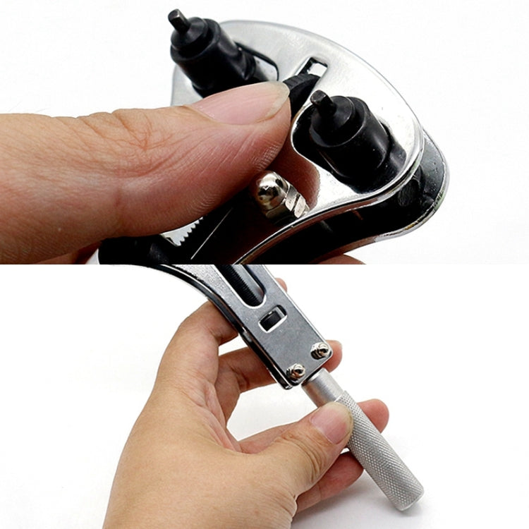 Watch case opener held by hands, steel head with black inserts and textured handle