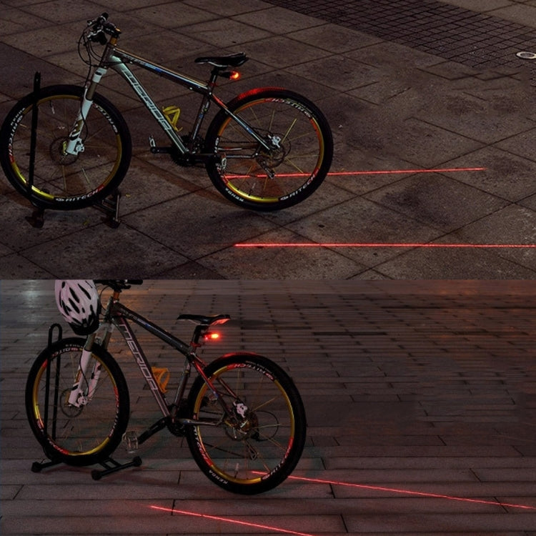 Bicycle rear red LED tail light casting a red laser line forward.