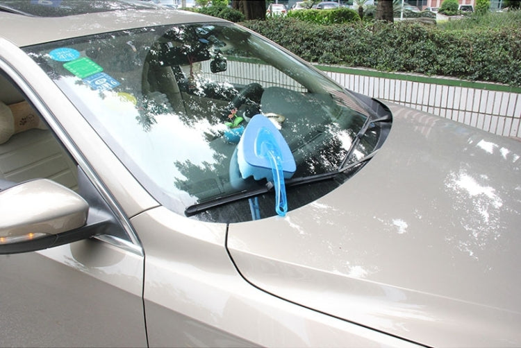 Blue car wash sponge with handle on a car windshield for cleaning