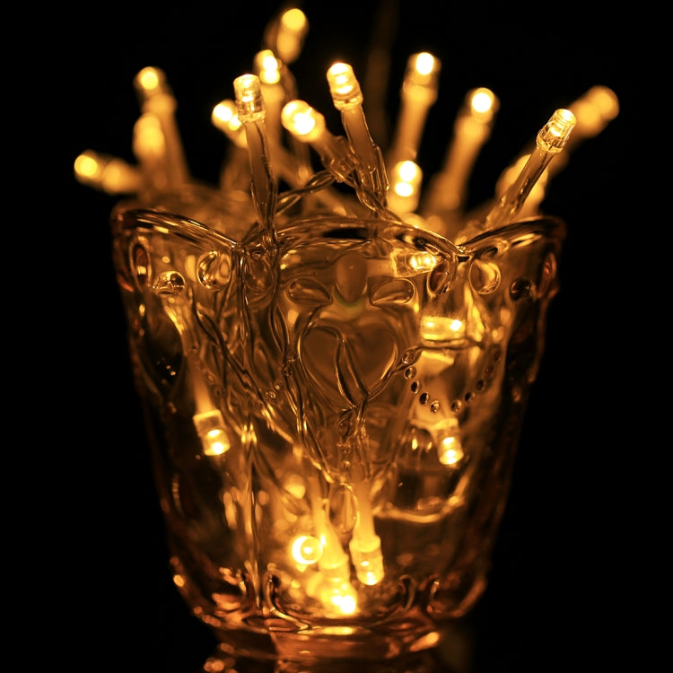 Warm white LED string lights wrapped through a gold-toned decorative cup