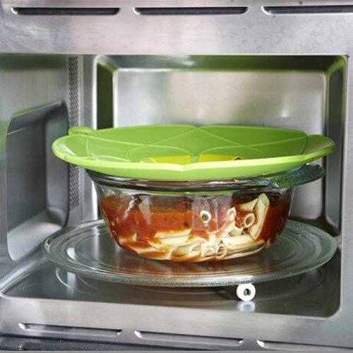 Green silicone pot cover on glass bowl, used in microwave oven
