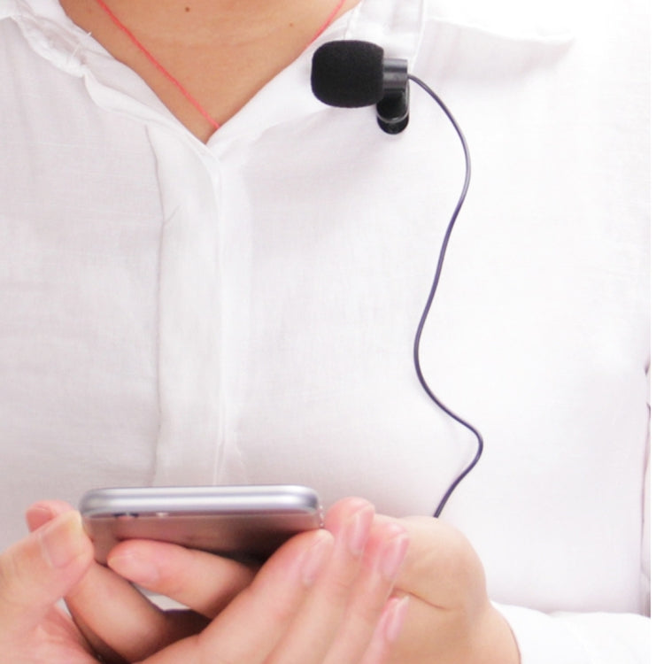 Clip-on wired microphone attached to shirt neckline with cable and connected phone