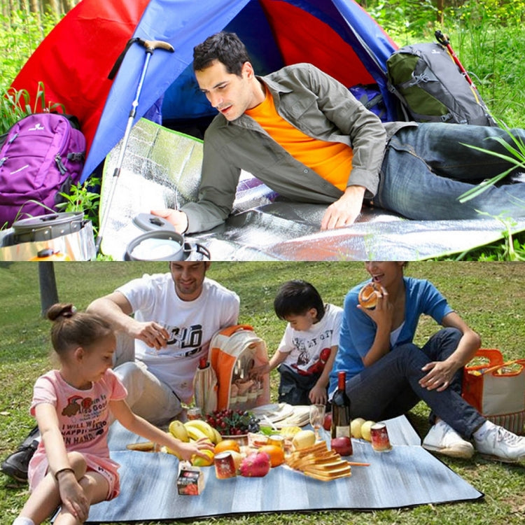 Reflective silver camping moisture pad spread on grass inside a tent