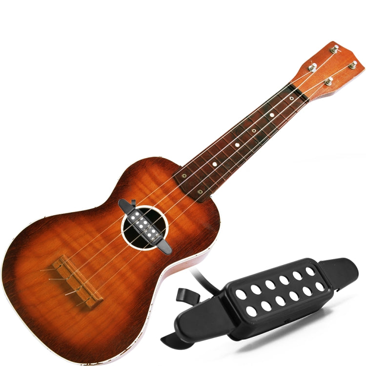 Wooden acoustic guitar with black sound hole pickup and perforated grille