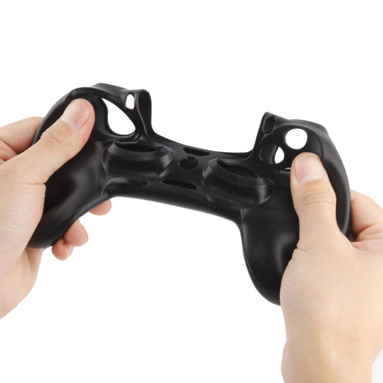 Hands fitting a black silicone controller case, showing rear cutouts and grips