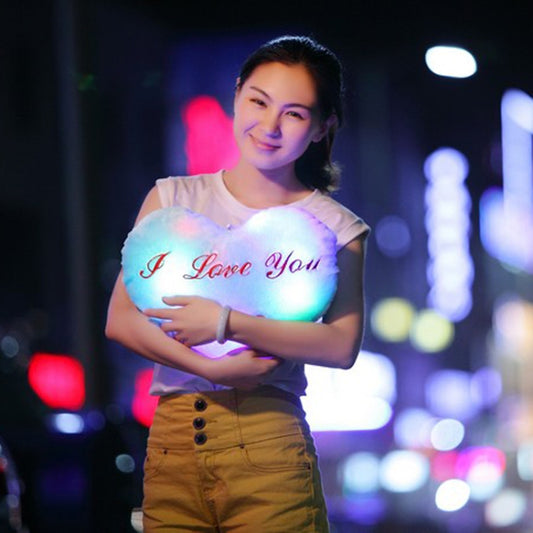 Blue-lit heart-shaped plush glow pillow with red 'I love You' script and button