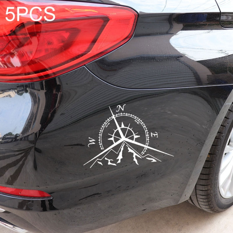 White compass rose decal with mountains and wind markings on dark car panel
