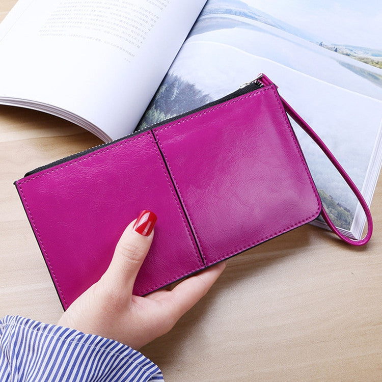 Rose pink zip long clutch wallet with wrist strap, held in hand