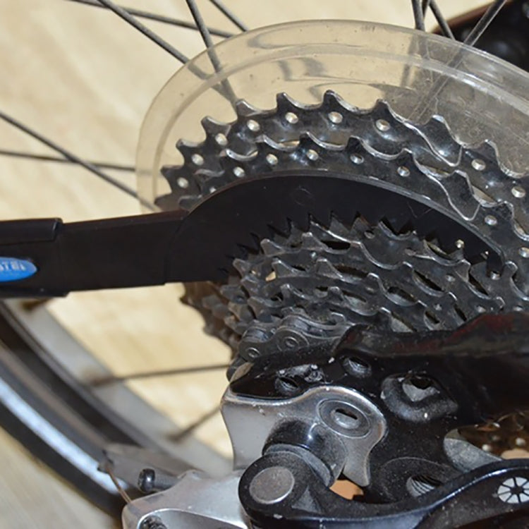 Cycling drivetrain cleaning tool brushing a bike cassette sprocket