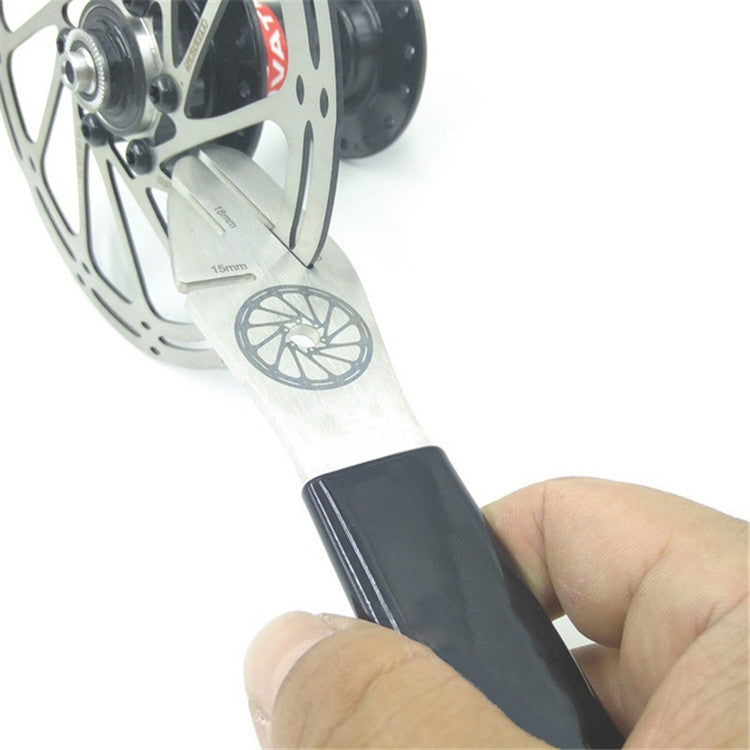 Disc brake alignment tool held against rotor, silver gauge with 16mm marking, black handle