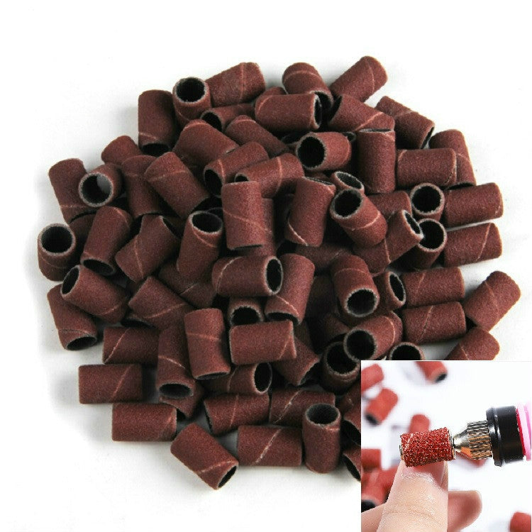 Brown-red sanding drum sleeves for nail grinder, scattered with inset of tool using one sleeve