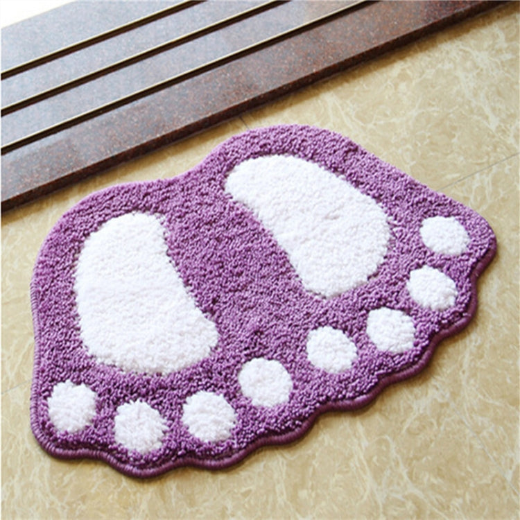 Purple foot-shaped shaggy bath mat with white paw prints and round dot border