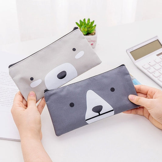Cartoon dog pencil pouches in light gray and dark blue held in hands