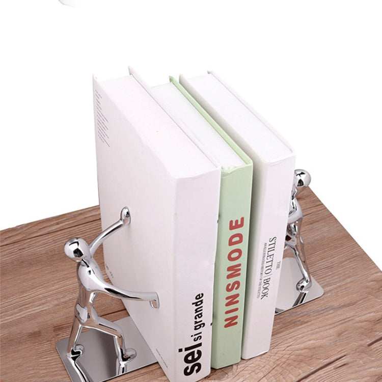 Humanoid book holders holding upright books on a desk, chrome figures and bases.
