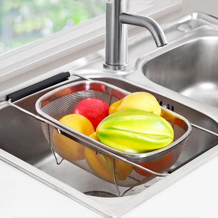Stainless steel folding strainer basket with produce in sink by faucet