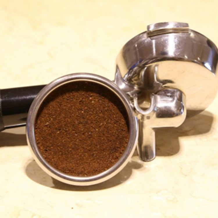 Espresso filter basket filled with dark coffee grounds on stainless portafilter
