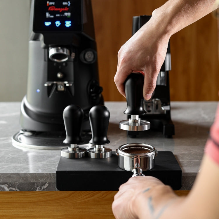 Coffee powder press hammer being used on an espresso machine with spare bases
